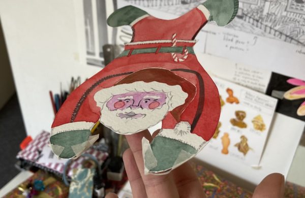 Image of Santa drawn on a card, balanced on a finger